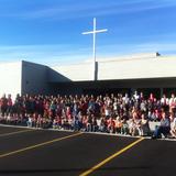 Anchor Lutheran School Photo #2 - Students and staff in front of the main entrance of our school, with the cross of Christ lifted above. In our whole program, Jesus is lifted up as the example we follow and the purpose to which we commit ourselves.