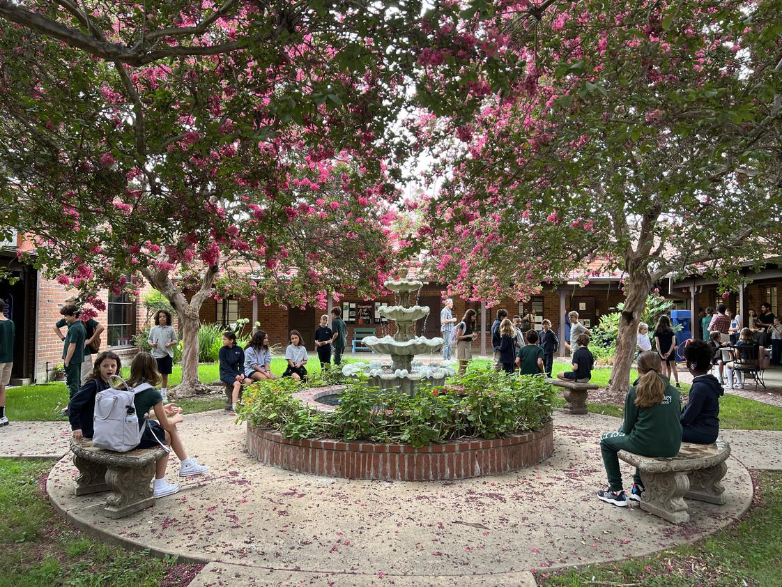 The Wesley School Photo #1 - Our 2nd and 6th Grade "Buddies" connecting and reading together in our fountain courtyard.