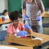 Living Wisdom School Of Palo Alto Photo #5 - Student conducts a hands-on chemistry experiment, carefully measuring liquids and observing reactions.