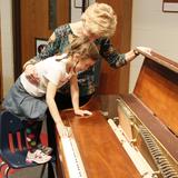 The Orchard School Photo #5 - At Orchard, students are encouraged to ask, "Why?" Here a preschooler learns why a piano sounds the way it does. She is able to see the hammers strike the strings as she presses the key on the keyboard.