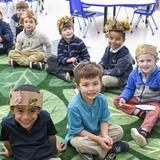 Gilman School Photo #2 - Gilman's Early Childhood Program embodies joy, happiness, and excitement. Our lessons promote exploration and discovery, resulting in a lifelong spirit of inquiry and learning. Here, Pre-K students show off their newly-made crowns celebrating autumn.