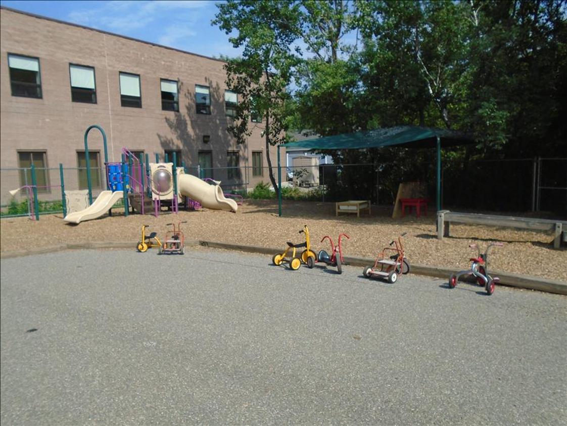 Ray Avenue KinderCare Photo - This is our large Preschool Playground! Our Preschool, Jr. K, and Pre-K students love getting some energy out in our large outdoor playground! There is a large concrete area for bike riding, chalk and other fun activities, as well as a large structure for climbing and sliding! A large tent covers an area of the playground to provide some shade while the teachers and students take their curriculum outdoors!