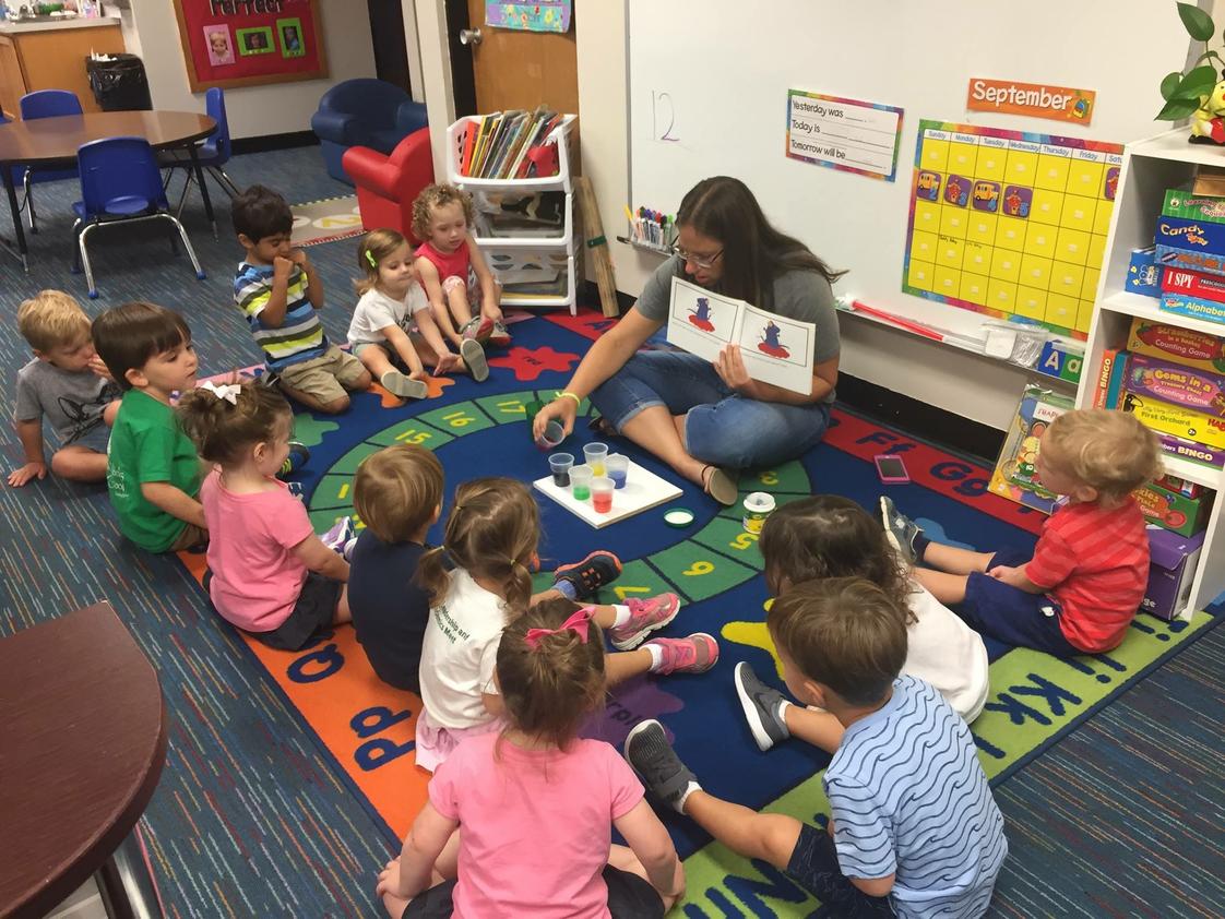 Rohan Woods School Photo #1 - Our Early Childhood class (Age 2) watches as Ms. Sullivan creates the colors in the book they are reading-- MOUSE PAINT. "It was magic, one little kiddo said as red and blue made purple!"