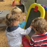 The Academy For Children Photo #6 - Easel fun outside at our playground! We go outside everyday! Our playground is fenced in and packed with all sorts of age appropriate fun!