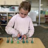 East Bay Montessori Photo #2 - A Lower Elementary student works on a Montessori Math material