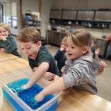 Sumner Academy Photo #2 - Kindergarteners take the polar plunge while studying habitats, comparing the feeling of ice water on bare hands vs 'blubber' wrapped-hands.