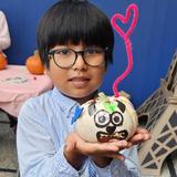 French Immersion School Of Washington Photo #9 - An elementary student shows his creation on a pumpkin during a Halloween decoration party on campus