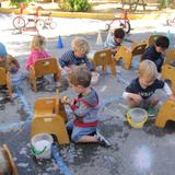 Montessori De Terra Linda Photo #7 - Our Pre-Primary (ages 2-3) students help care for their classroom by washing their chairs. Water "work" is so much fun!