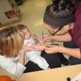 East Cedar Rapids KinderCare Photo #8 - Ms. LeAnne is painting his hand with face paint at an open house!