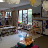 Apple Valley KinderCare Photo #5 - A different view of the toddler classroom. The large tables are also used as an area for the children to participate in large and small group activites, art projects as well as playing with the various bucket toys and puzzles. The toddlers also have access to a sensory table that is filled with something new each month that reflects on what they are learning.