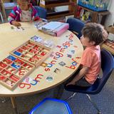 Christian Montessori Academy Photo #7 - Children's House student word building using the moveable alphabet as part of our language curriculum.
