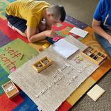 Christian Montessori Academy Photo #8 - Using the hands-on materials, an Upper Elementary student learns about the distributive property of a sum multiplied by a sum. This concept is an introduction to pre-algebra.