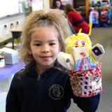 Primoris Academy Photo #5 - Student proudly holds up her creation for the puppet show that our youngest grades put on.