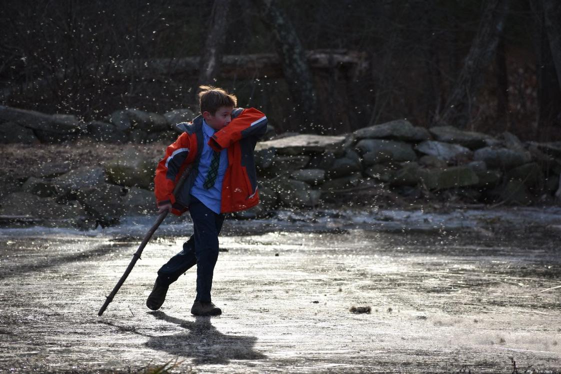 Sparhawk Academy Photo - A Sparhawk boy ventures forth onto a frozen brook on campus. Direct engagement with creation is a cornerstone of our curriculum.