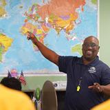 Lake Rose Christian Academy Photo #8 - A Lake Rose Christian Academy teacher leads an engaging geography lesson, pointing to a world map as students follow along.
