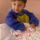 Montessori Childrens Academy Photo #4 - The image captures a vibrant moment in a preschool sensorial activity class. A young child, engaging in an immersive tactile experience. Our student is joyfully mixing shaving cream and red paint, creating a swirled, textured spread. This hands-on activity is classic sensory play, it encourages exploration of texture, color, and movement, all essential for developing fine motor skills and creative expression. This type of sensory-rich learning beautifully illustrates how early education inspires curiosity through hands-on exploration and play