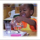 Oak Meadow Montessori Photo - Children love the area of Practical Life in the Montessori classroom. This student is happily pouring water and learning fine muscle control and how to serve a beverage to his friends.